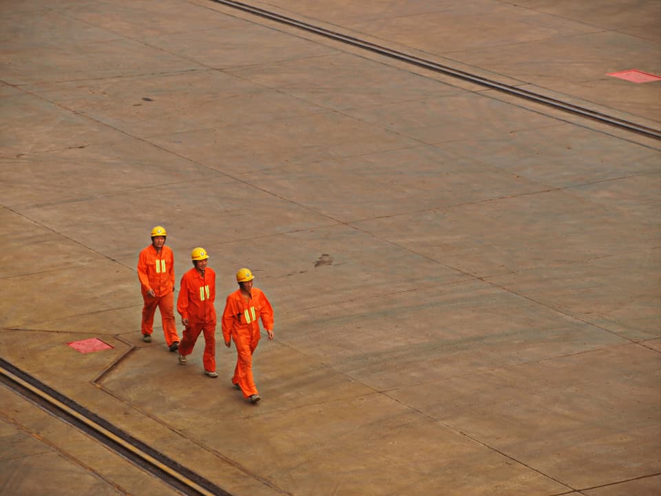 Field crew in safety helmets walking across a work site